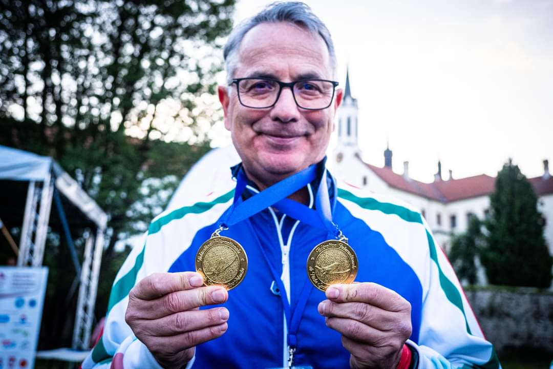 Valerio Santi Amantini holding up two medals around his neck