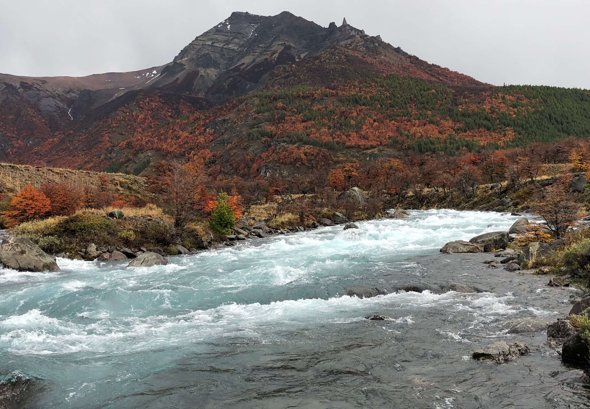 Fall mountain backdrop with a flowing river